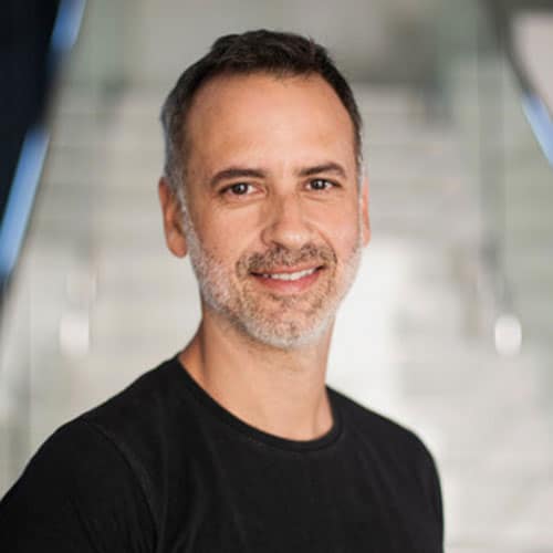 Homem sorridente em ambiente moderno, representando o instituto de educação e inovação Instituto Ar.